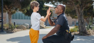 Police Officer and a Child High-Fiving