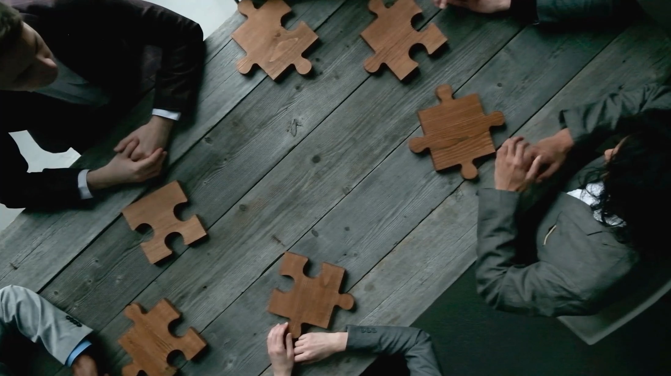 People sitting a table with puzzle pieces