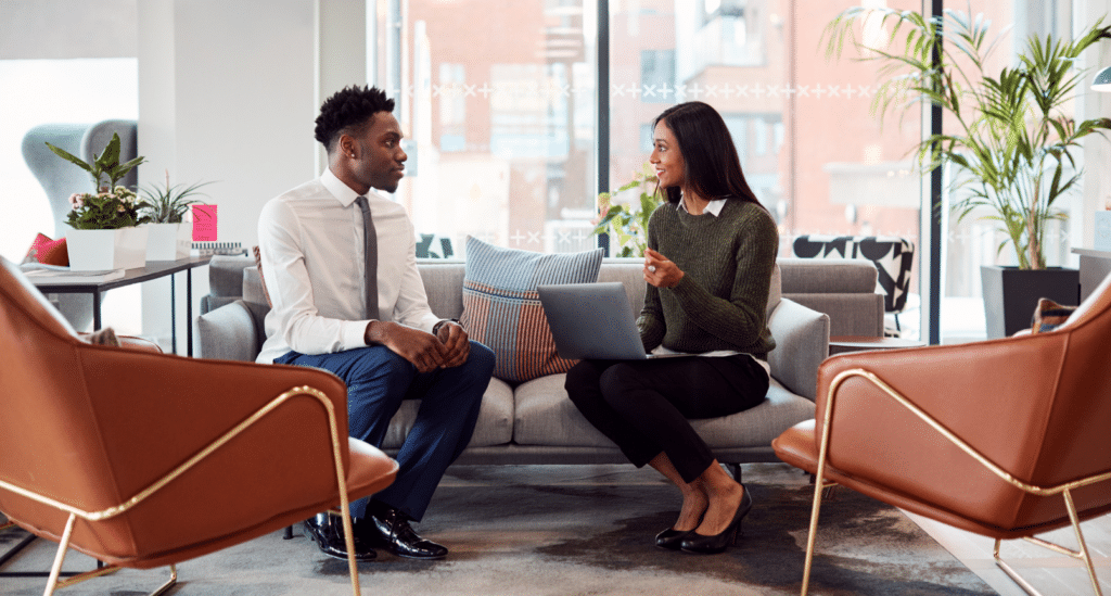 Two employees in the office sitting on a couch